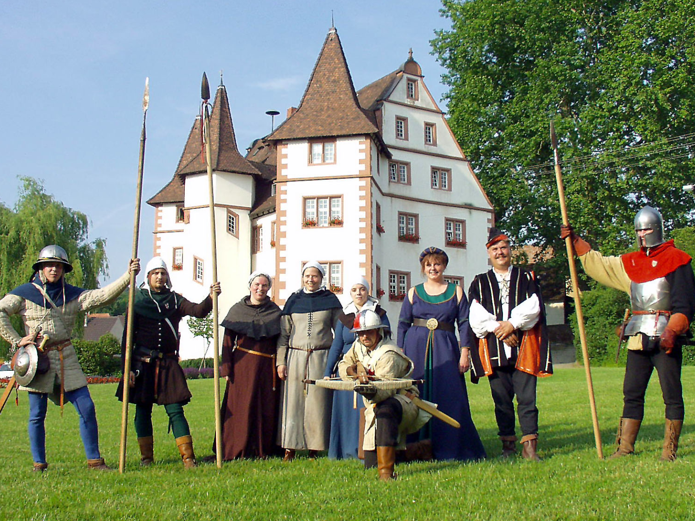 Bild: Traditionell gekleidete Menschen vor dem Schloss